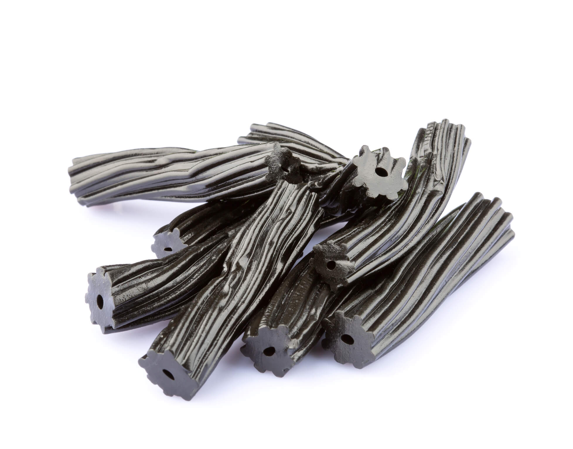 A pile of pieces of black licorice against a clean white background