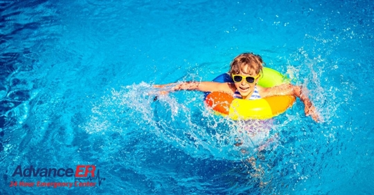child in pool wearing floating tube