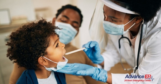 little boy getting his throat checked at the doctor