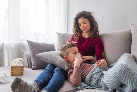 mom taking kids temperature