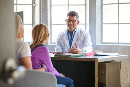 Doctor consulting with a mother and her daughter about treatment.