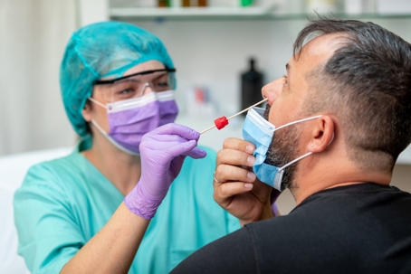 patient undergoing nose swab test from medical professional