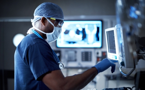 Shot of a physician looking at a monitor in an operating room