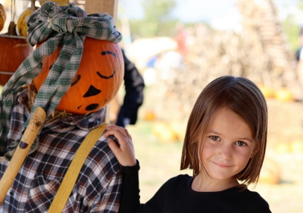 Girl with pumpkin scarecrow