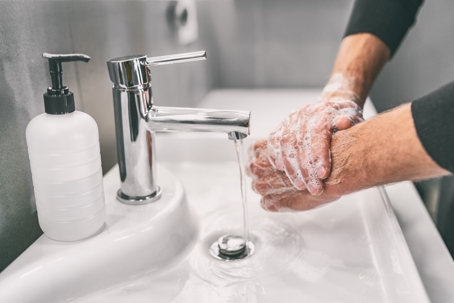 person-washing-their-hands-at-white-sink