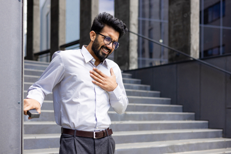 Young man with chest pain symptoms, holding chest and appearing in distress