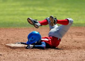 Baseball player sliding into base face-first.