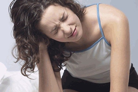 Woman cringing in pain.