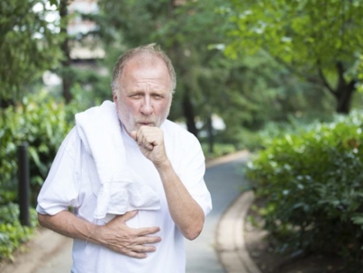 Elderly man coughing into his fist
