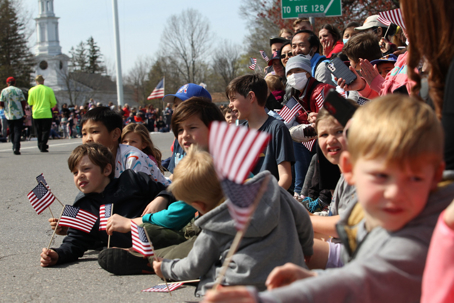 Families and children gathered during a Memorial Day parade weekend, highlighting outdoor holiday activities and common Memorial Day safety concerns.