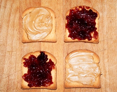 peanut butter and jelly spread onto four pieces of bread
